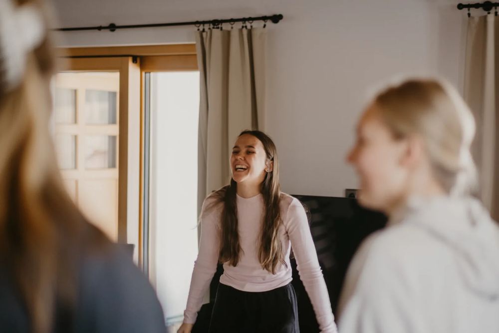 Alisa se směje se studentkami na hodině zpěvu